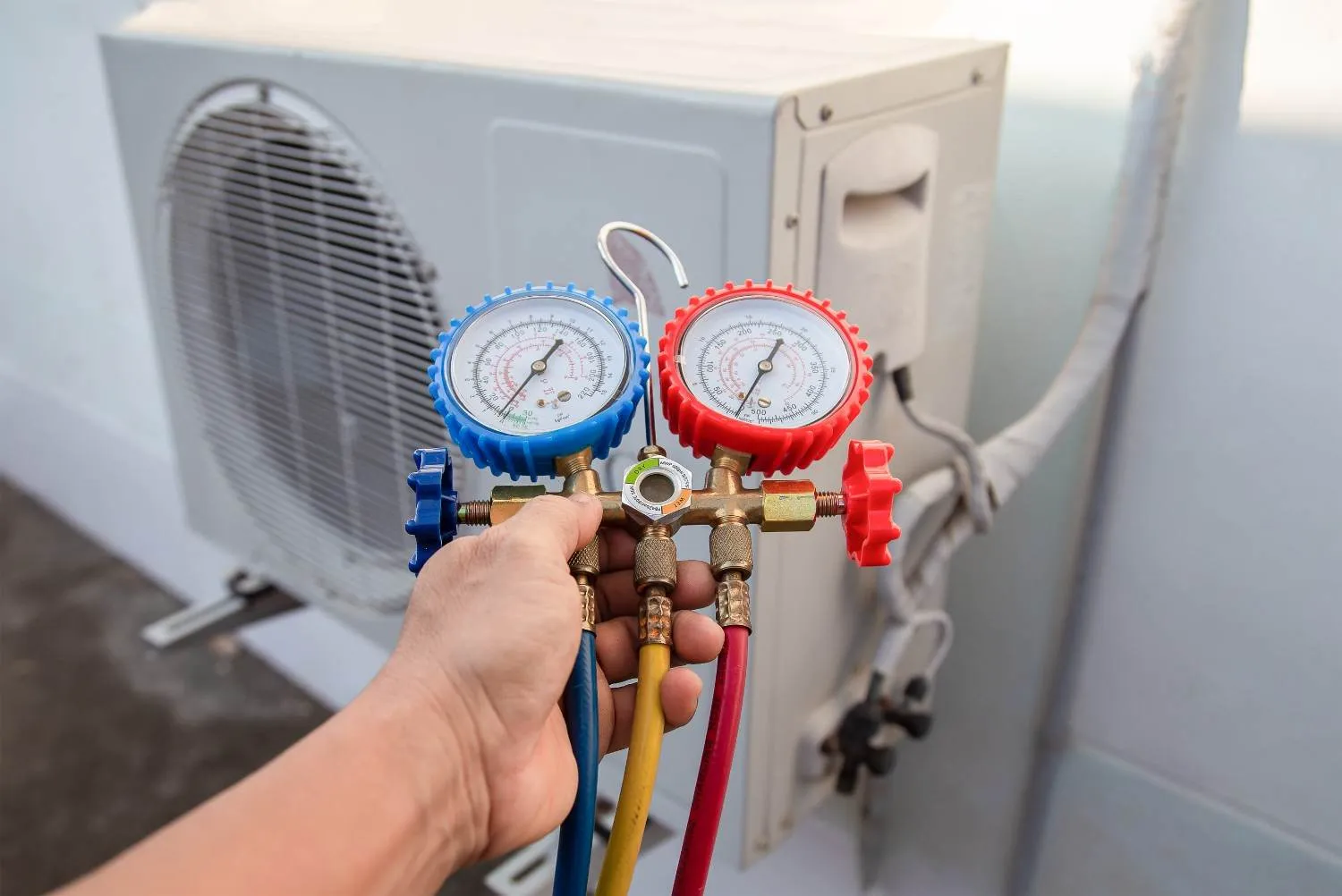 Pressure gauges connected to an air conditioner unit